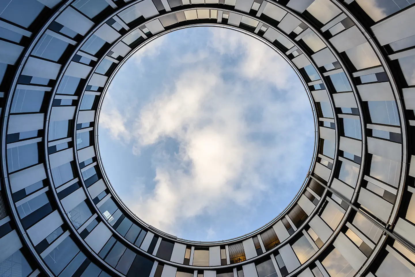 Clouds reflected in windows of modern office building