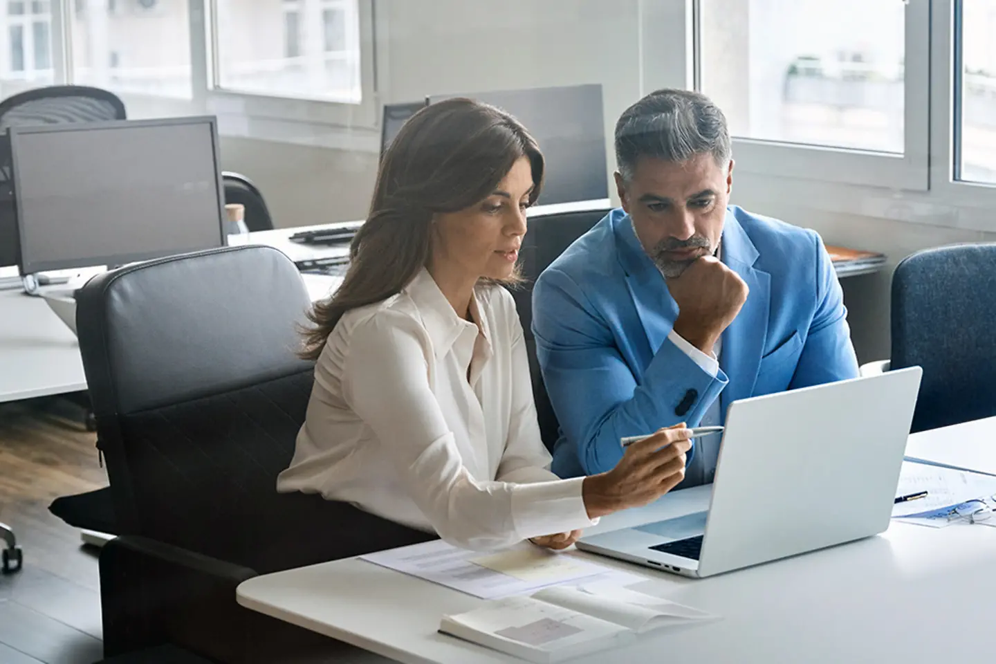 Employees of the spanish Treasury checking data on a laptop