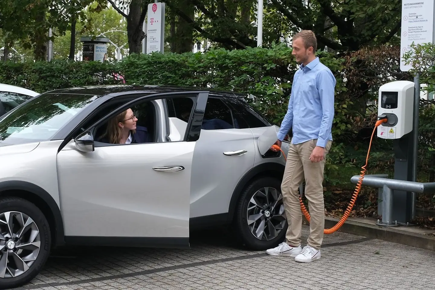 Mann charging an electric car at a charging station